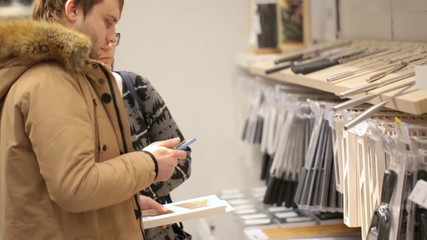 Young couple are choosing crockery at shop - Powered by Adobe