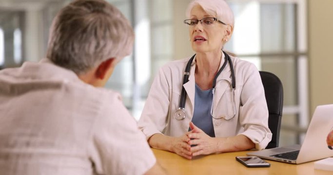 Highly educated doctor discussing health concerns with elderly man