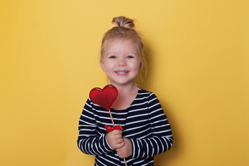 Pretty girl with red bright lollipop candy on yellow background valentines day holiday love theme
