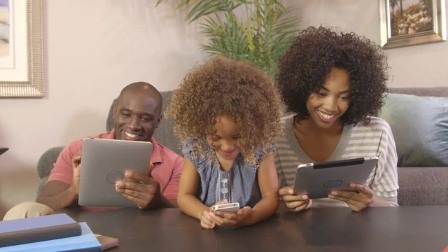 African American Family Using Cellphone And Tablets