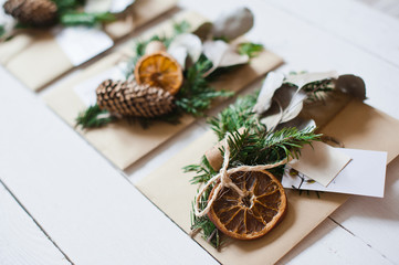 Craft envelopes with natural decoration on the white wooden desk.