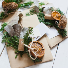 Craft envelopes with natural decoration on the white wooden desk.