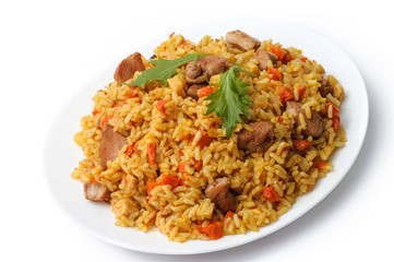 rice pilaf with meat and vegetables top view on a plate. Isolated on white.