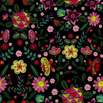 Embroidery ethnic seamless pattern with small wild fantasy flowers. Vector embroidered floral design for fashion wearing.