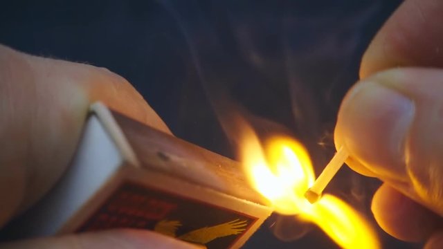 The match in the hand moves on the side of the matchbox and light the fire. S-log - High Dynamic Range. Macro. Slow mo, slo mo, slow motion, high speed camera, 240fps, 250fps