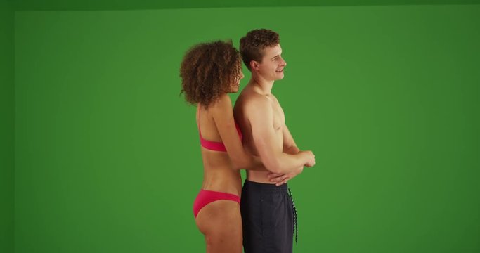 Portrait of young attractive couple holding each other on green screen. On green screen to be keyed or composited. 