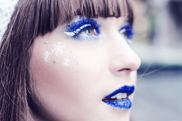 Beautiful teenager with blue and white snowflake make-up
