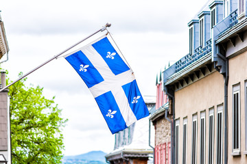 Closeup of blue flag in upper old town street Quebec City, Canada looking down steep hill