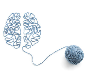 Ball of yarn and thread in the shape of the brain on a white background - obrazy, fototapety, plakaty