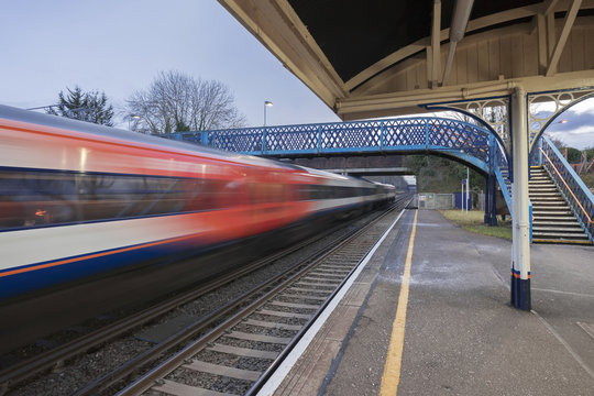 Fast express train passing through a Victorian UK station in southern England