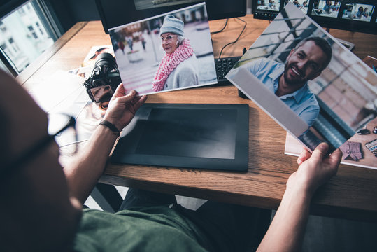 Top View Male Hands Keeping Pictures Of Old Lady And Outgoing Bearded Male While Situating At Table In Room. Profession And Hobby Concept