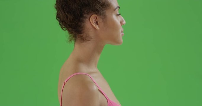 Young african American girl in gym clothes looks at the camera on green screen. On green screen to be keyed or composited. 