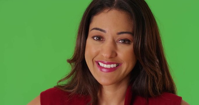 Close up of cheerful Latina female smiling at camera on green screen. On green screen to be keyed or composited. 