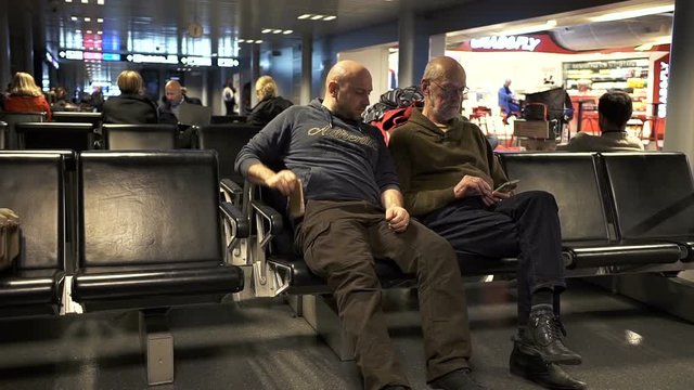 Two caucasian type men talking in the airport lounge