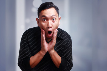 Fototapeta na wymiar Funny Young Asian Man Amazed Shocked Gesture