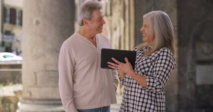 Old white married male and female use tablet at Pantheon in Rome