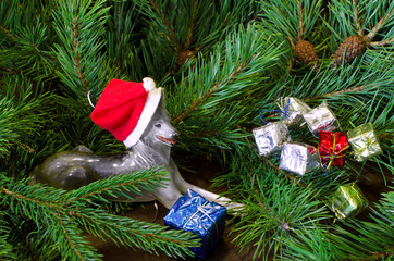 porcelain dog shepherd dog in Santa Claus hat and Christmas gifts