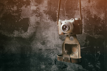 Old retro camera with dark wall background. Soft focus.