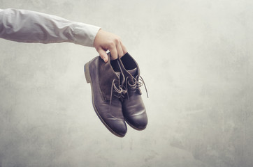 Businessman`s hand with brown leather shoes