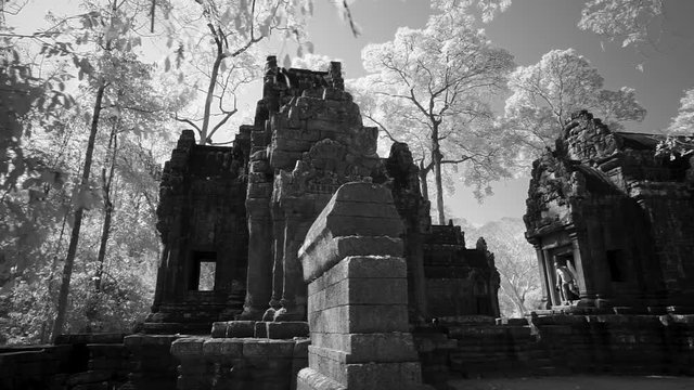 Starting in the trees the steadicam gimbal reveals the Wat Thommanon in the Angkor Wat architectural world heritage site.