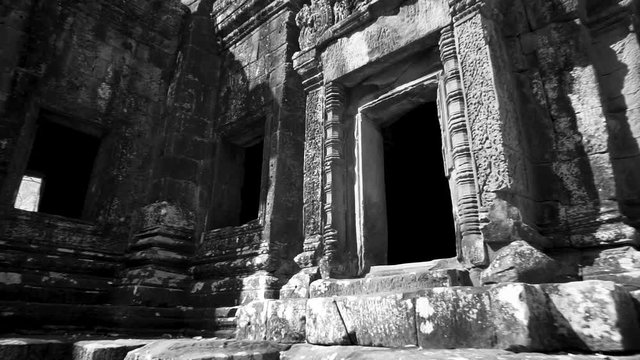 Closeup steadicam gimbal moving through the trees towards Wat Thommanon in the Angkor Wat architectural world heritage site.