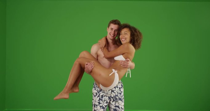 Cute couple smiling on while holding each other on green screen. On green screen to be keyed or composited. 