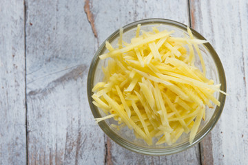 Ginger cut into strips on wooden table