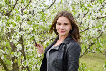 Beautiful fairy young girl in a flowering plum garden. Portrait