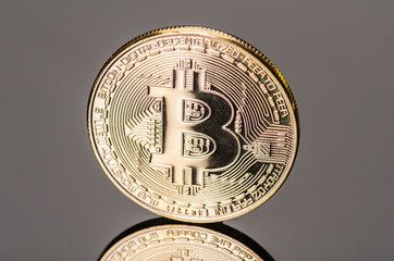 bitcoin symbol coin on a black acryl mirror