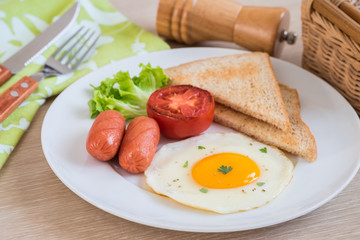 Breakfast with fried egg, toast, sausage and vegetable on table