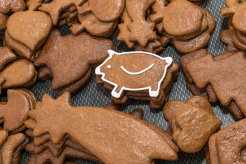 Cute New Year piggy for good luck from Christmas gingerbread. Piles of differently shaped pastries...