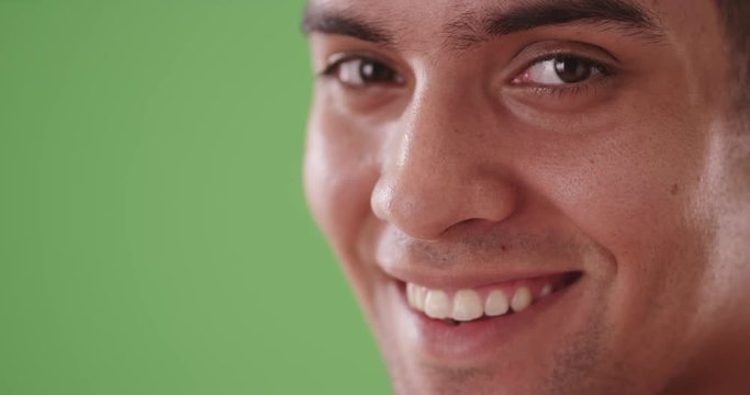 Close up portrait of Latino man looking at camera on green screen. On green screen to be keyed or composited. 
