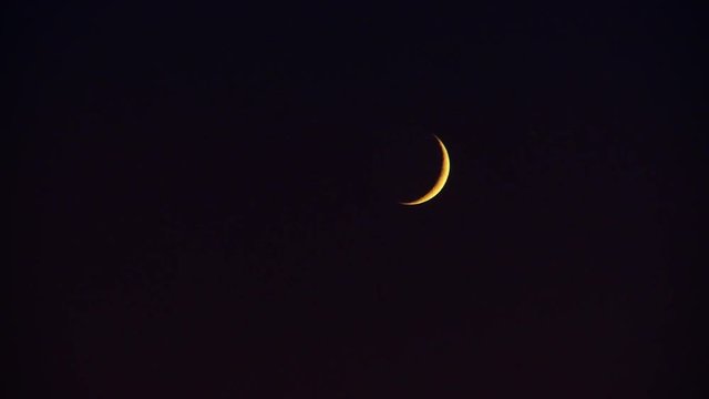 yellow crescent moon against black sky