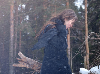 girl walking in winter forest in bad weather