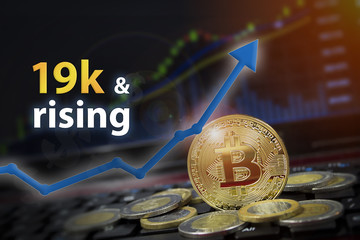 Bitcoin currency rising arrow price record highs on keyboard computer with golden bitcoin and other currencies.