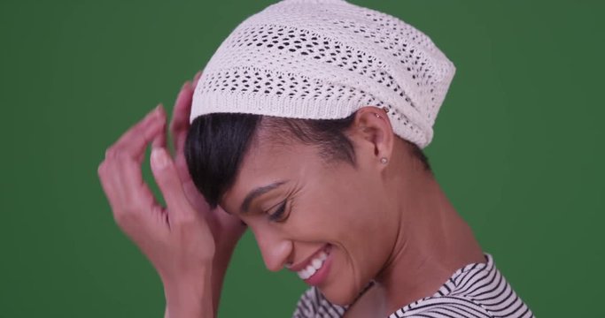 Happy smiling black woman with hipster beanie on green screen. On green screen to be keyed or composited. 