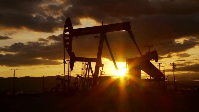 Oil well piston pumps at sunset