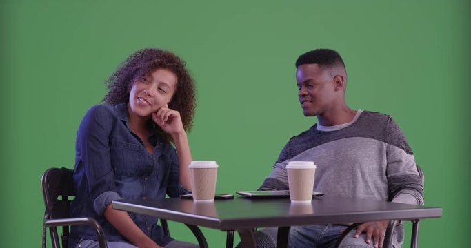 Millennial black couple have coffee on green screen. On green screen to be keyed or composited. 