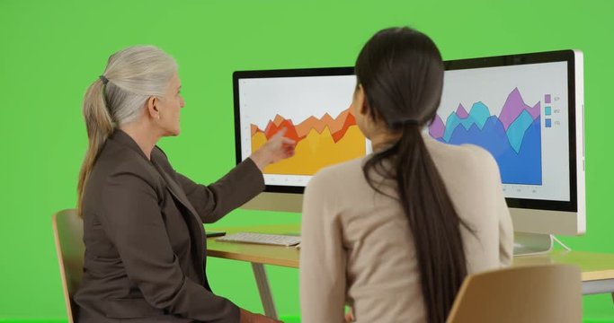 Two office professionals talk about their company's statistics on green screen. On green screen to be keyed or composited. 