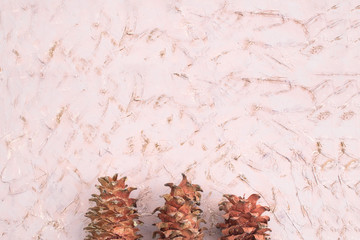 Three large pine cones on a textured background.