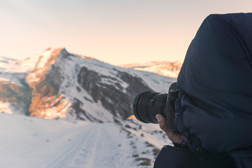 Fototapeta na wymiar Nature photographer in winter mountains