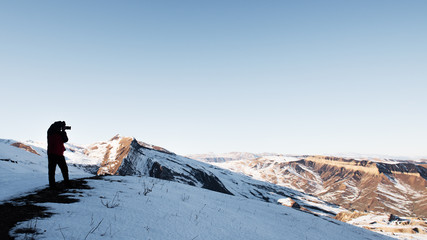 Nature photographer in winter mountains