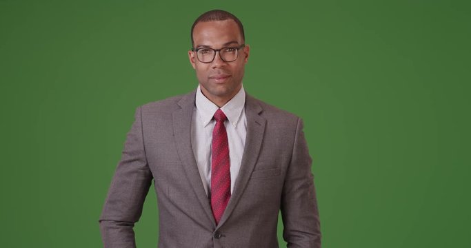 A black businessman poses for a portrait on green screen. On green screen to be keyed or composited. 