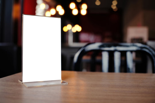 Mock up Menu frame standing on wood table in Bar restaurant cafe. space for text