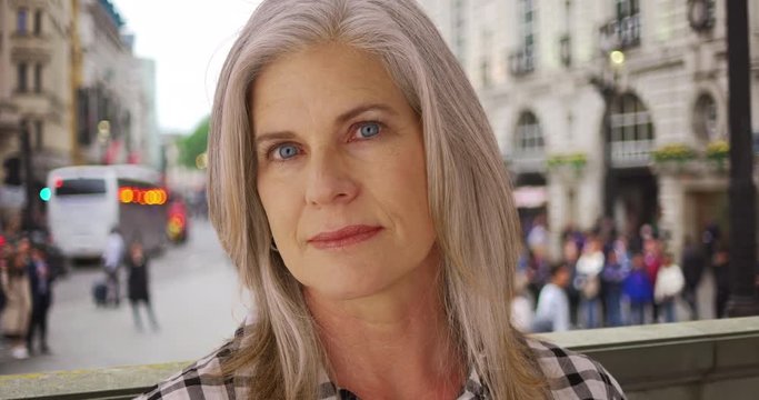 Senior Caucasian lady looks up and stares longingly in a London street