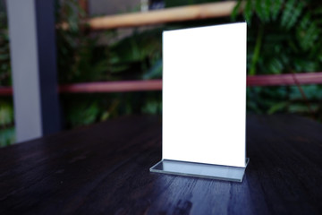 Mock up Menu frame standing on wood table in Bar restaurant cafe. space for text.