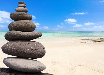 galets superposés zen sur fond de plage mauricienne