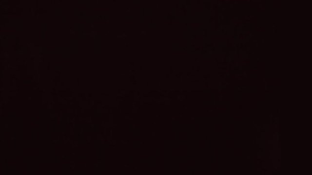Black remote control flies and rotates on a black background. Close Up. Slow mo, slo mo, slow motion, high speed camera, 240fps, 250fps