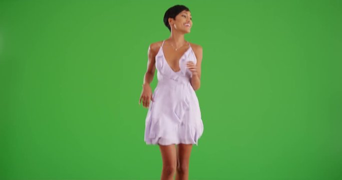 Beautiful black woman skips toward the camera on green screen. On green screen to be keyed or composited. 