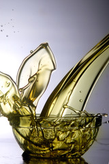 Liquid cooking oil splashes when poured into a glass bowl